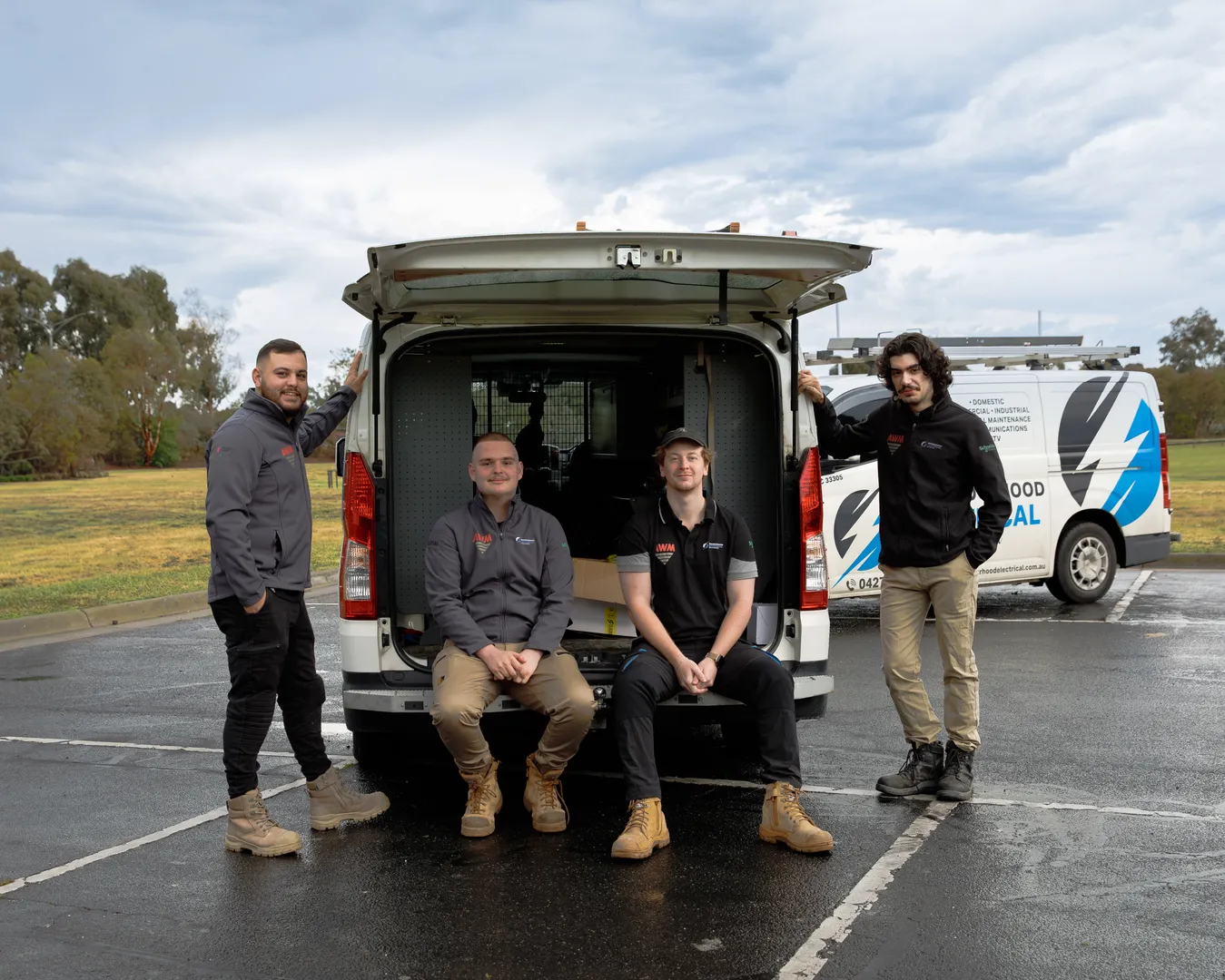 Four electricians by their work van.